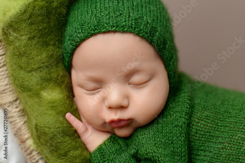 Sleeping newborn boy on a brown  background. 