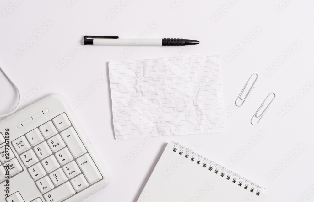 White pc keyboard with empty note paper and pencil above white background. White pc keyboard with empty note paper and pencil above white background.