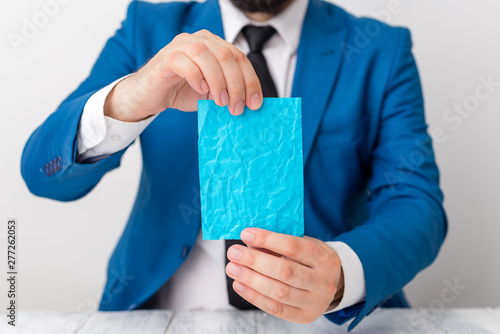 Man holds empty paper with copy space in front of him. White space for advertising message.