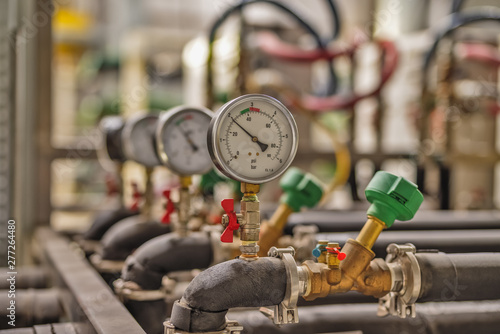Gauge closeup, pressure measurement . Pipes and valves in the industrial enterprise.
