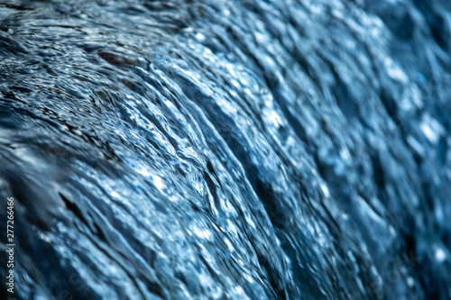 Water cocept - river water flowing with light reflecting of its surface