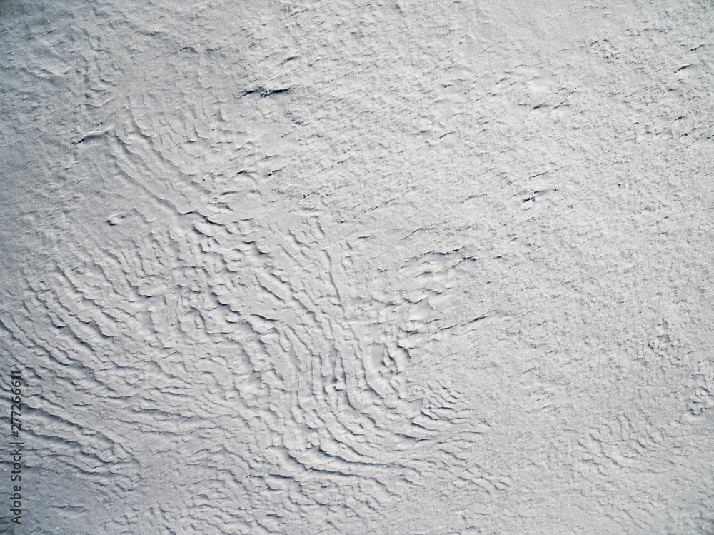 Fototapeta premium Aerial view above snowy plain on a winter frosty day