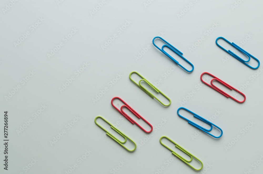 colorful metallic clamps and paper clips on white background colorful metallic clamps and paper clips on white background