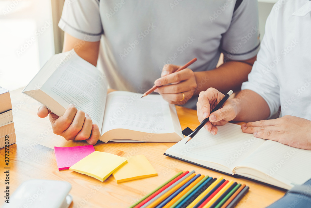 High school or college students studying and reading together in library High school or college students studying and reading together in library