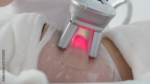 Woman getting cryolipolysis fat treatment procedure in professional cosmetic cabinet, closeup photo