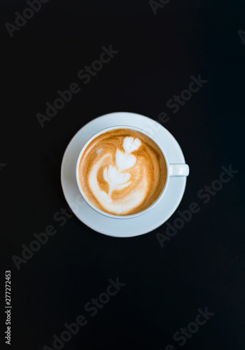 A cup of delicious latte coffee on wooden table background. Beautiful latte or cappuccino beverage art.