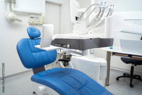 Empty modern dentist office with blue chair 