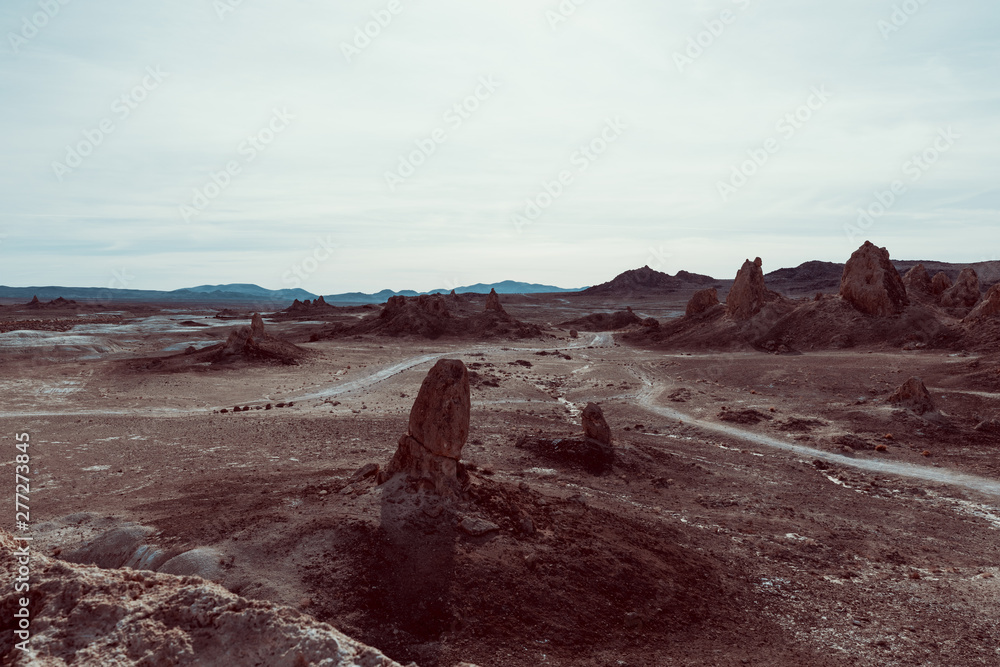 trona pinnacles seen from above. View of the formation. Dirty road and mountains in the background. 