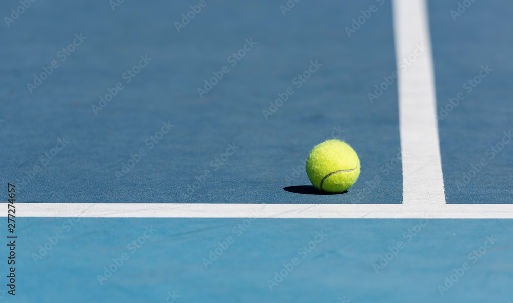 Tennis ball on blue tennis court