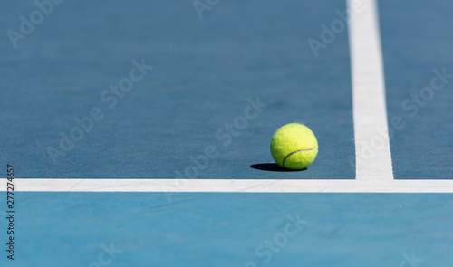 Tennis ball on blue tennis court