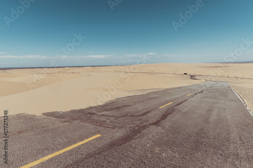 a road in the middle of the sand dunes in the desert.
