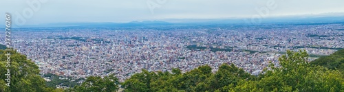 Panorama beautiful landscape view of Sapporo City from viewpoint of Mount Moiwa in cloudy day at Hokkaido, Japan. © Angkana