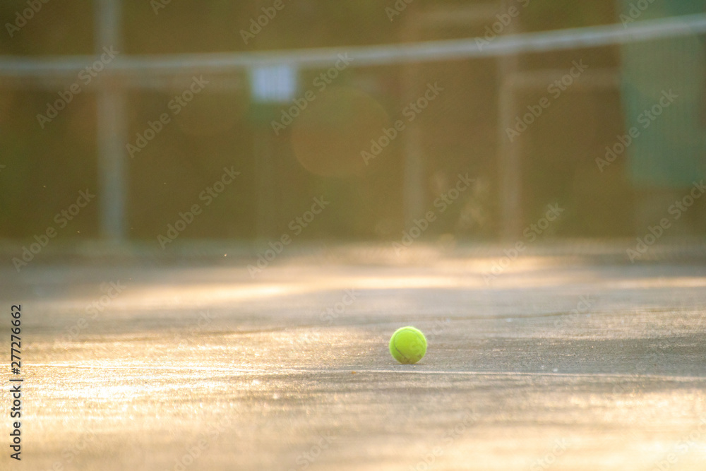 tennis court with ball and net on a summer day under sunshine