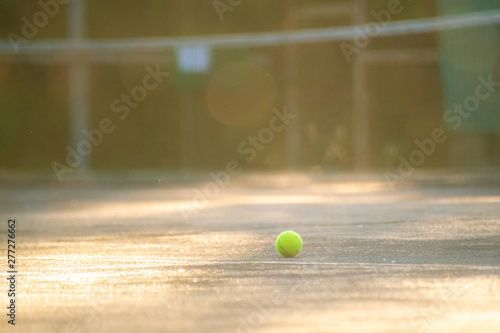 tennis court with ball and net on a summer day under sunshine
