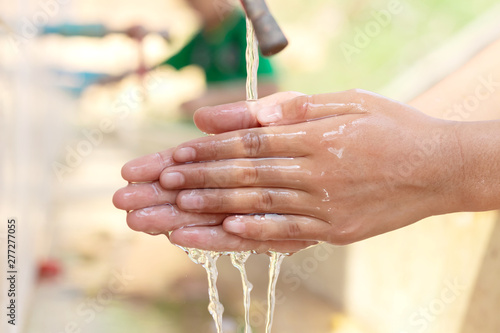 Close Up child hands under the stream of splashing water, environmental issues