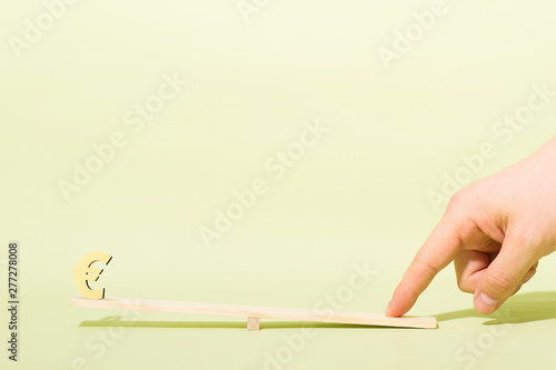 Finger and seesaw, currency symbol