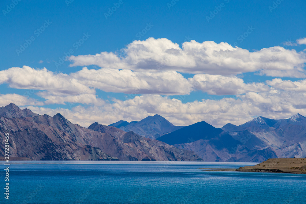 View of majestic rocky mountains against the blue sky and lake Pangong in Indian Himalayas, Ladakh region, India. Nature and travel concept