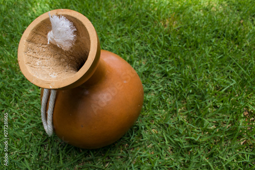 Hawaiian instrument, ipu, a carved, hollowed out gourd, on grass. In modern times it is used to keep the beat for hula dancing. It has also been used for food medicine and decoration.