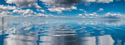 Cloudy sky reflected on oscillating water ripples photo