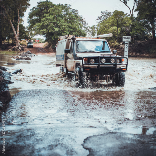 A 4WD crosses a dangerous and deadly river infested of crocodiles in Northern Territory Australia