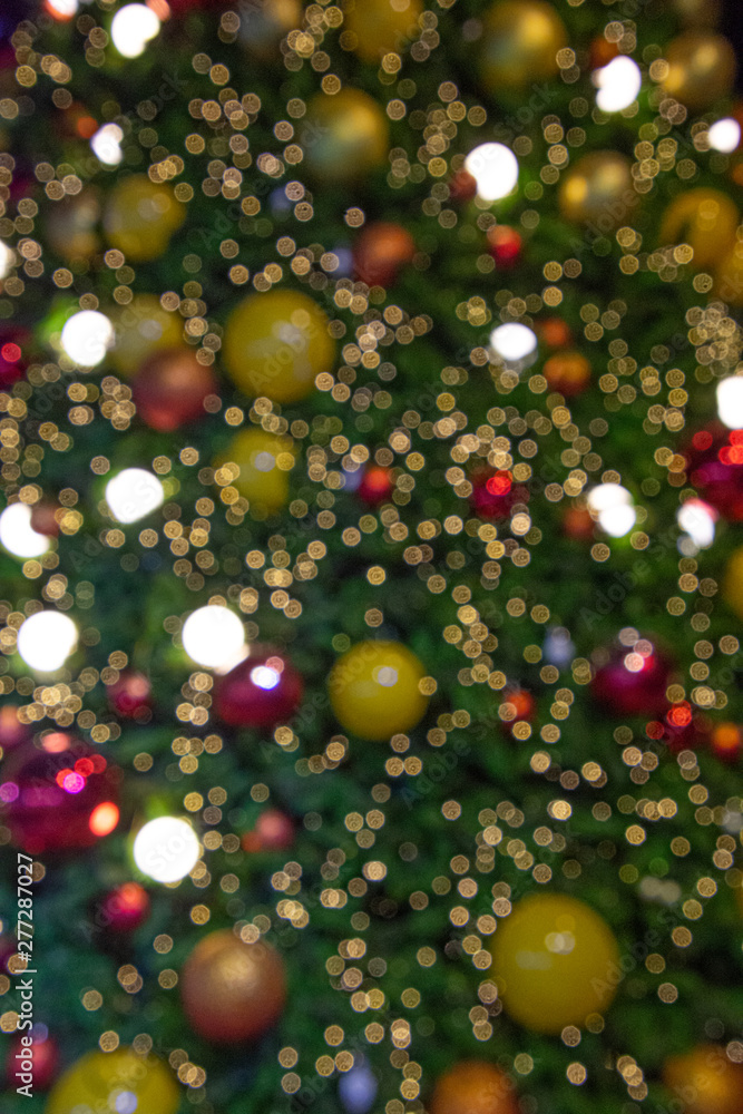 Illuminated  blurred bokeh of  Christmas tree decoration with  hanging lights ball.