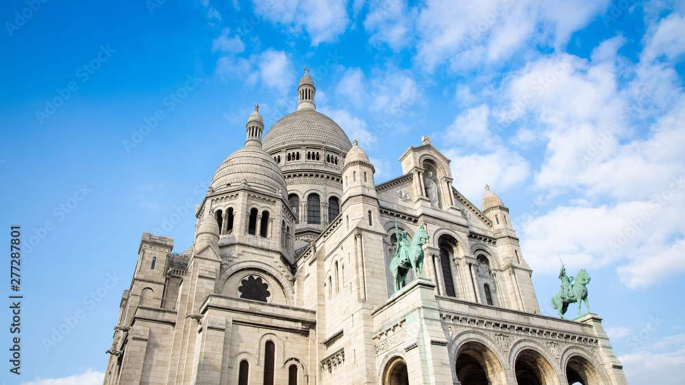 Basilica of the Sacre Couer on Montmartre with blue sky and clouds , Paris, France. Catholic church cathedral is popular in Europe