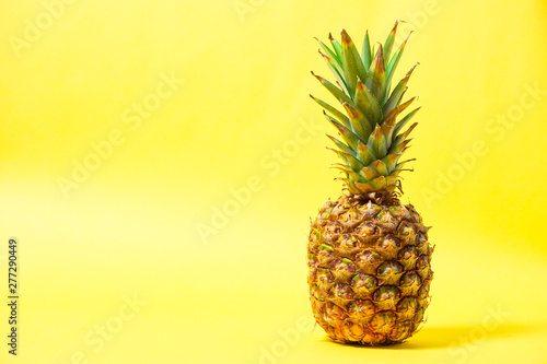 Ripe pineapple on the yellow background                                            