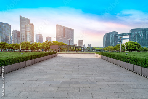 Empty square tiles and skyline of urban buildings..