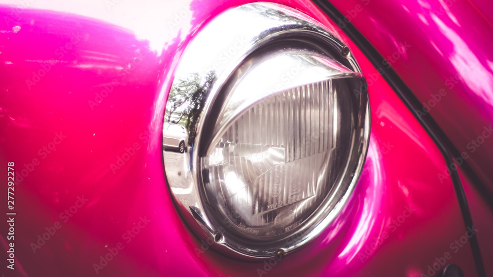 Close-up of headlights of pink  vintage retro beautiful vehicle car