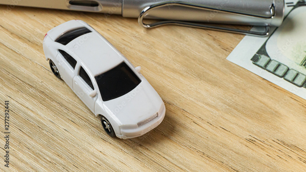 white toy car on work station table in office.. white toy car on work station table in office..