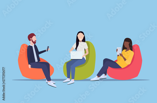 businesspeople sitting in bean bag armchair mix race colleagues team using digital gadgets social media communication concept flat full length horizontal