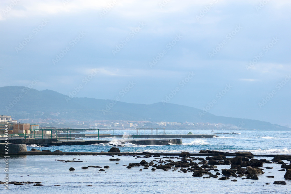 Winter view of coastline of Mediterranean sea near Livorno, Italy with mountains on the background