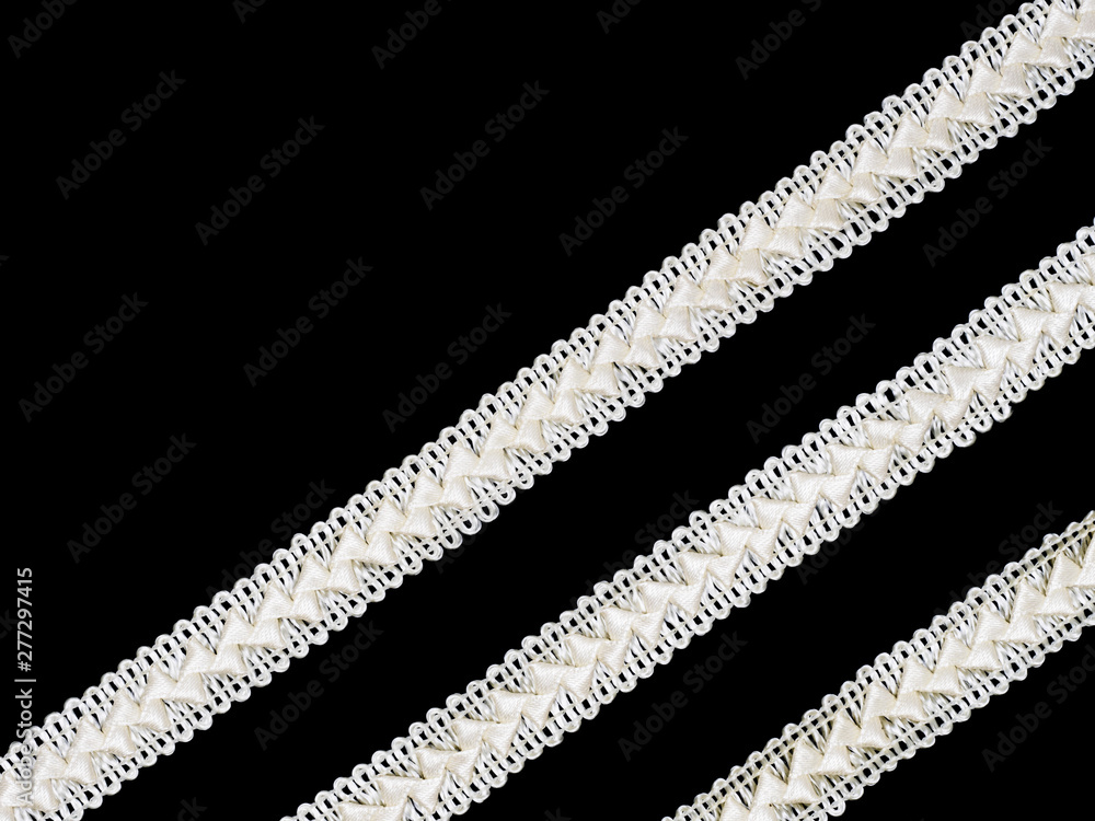 Fototapeta premium Beige laces on black background