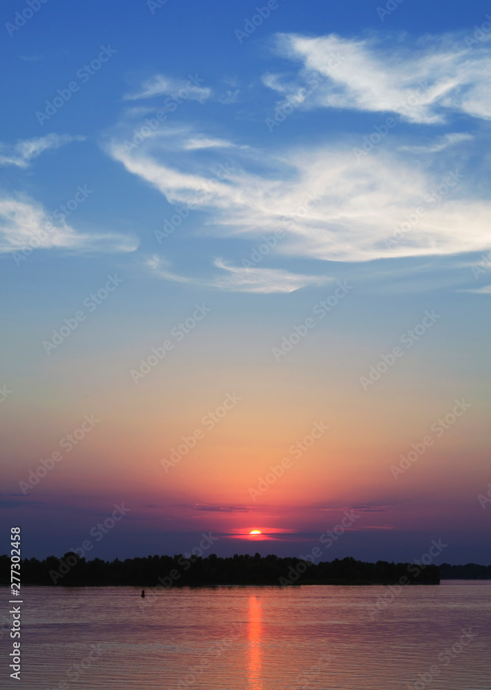Blazing sunset over the evening river. Flaming sky - the landscape in the setting sun. Amazing colorful sunset over river Dnieper. Blazing sunset over the evening river. Flaming sky - the landscape in the setting sun. Amazing colorful sunset over river Dnieper.
