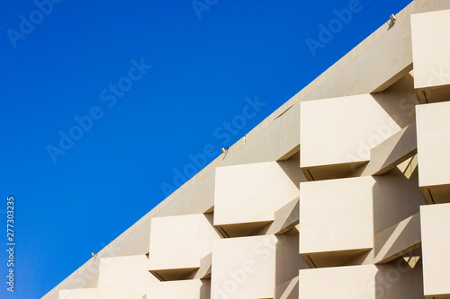 common living building concrete wall and windows facade exterior architecture diagonal background board with blue sky, empty space for copy or text