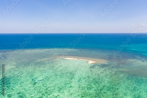 Sandbar on a coral reef. Atoll with a small sandy island. Seascape in the Philippines, view from above.