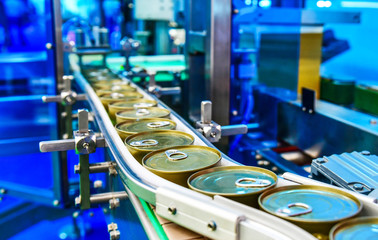 Canned food products on conveyor belt in distribution warehouse.parcels transportation system concept.