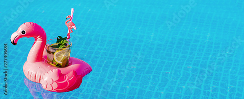 Fresh coctail mojito on inflatable pink flamingo toy at swimming pool. Vacation concept. photo