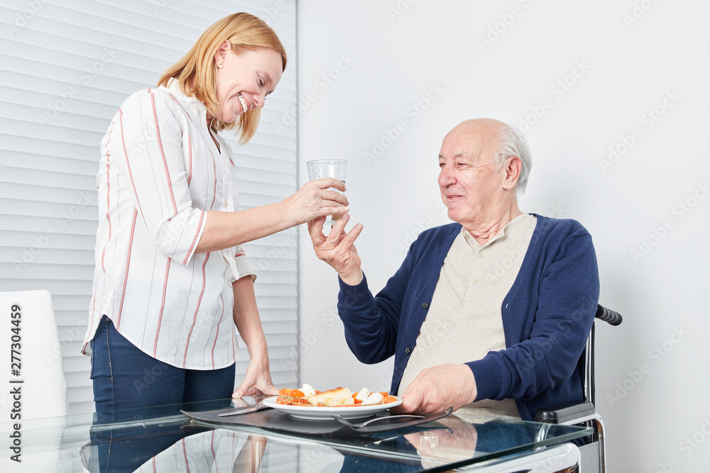 Obraz premium Young woman serves senior lunch