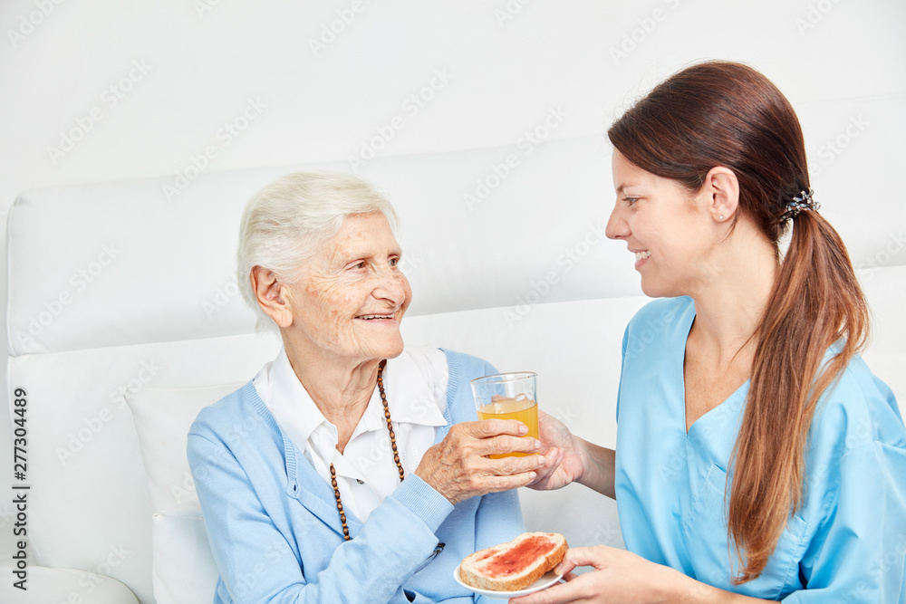Nursing woman brings senior citizen a juice Nursing woman brings senior citizen a juice