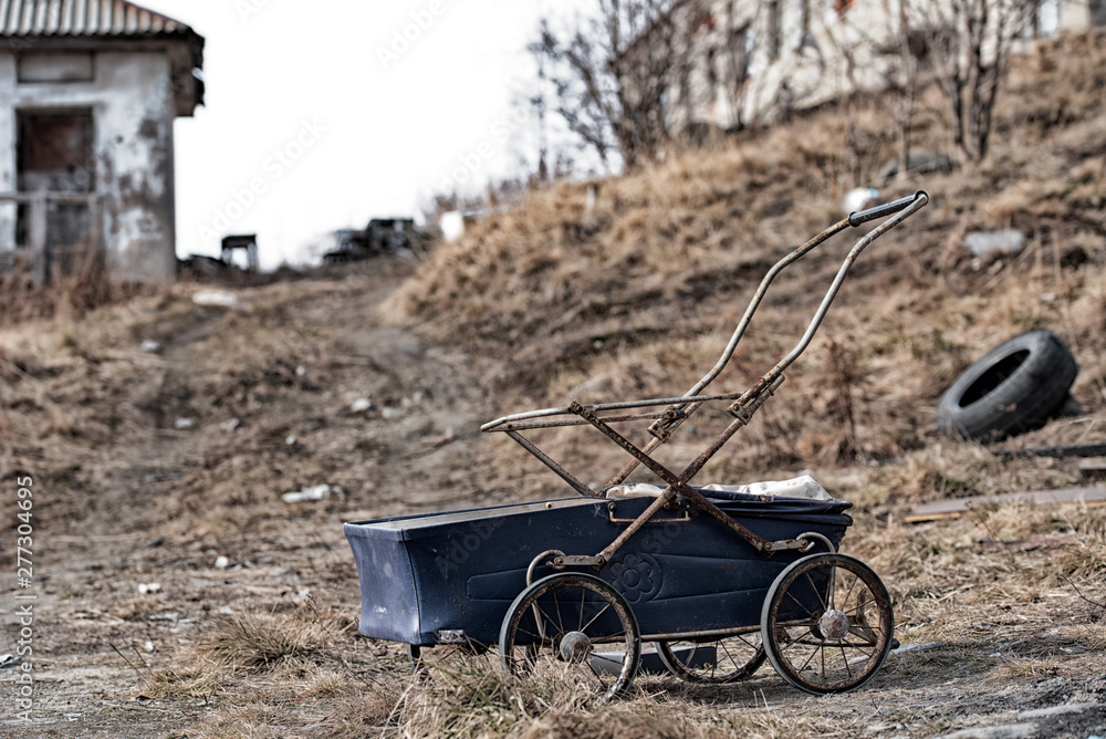 Blue baby carriage against the background of the abandoned apocalypse area Blue baby carriage against the background of the abandoned apocalypse area