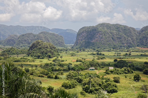 Vinales, Cuba - July 27, 2018: Green caribbean valley with small cuban houses and mogotes hills landscape panorama, Vinales, Pinar Del Rio, Cuba