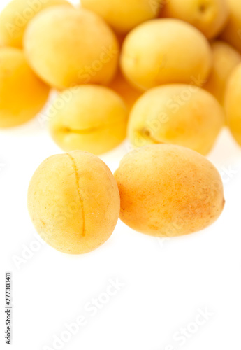 fresh yellow apricots against white background