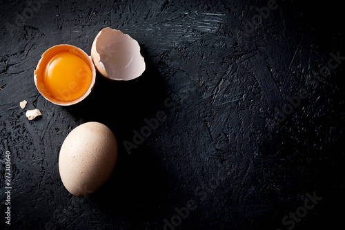 Organic chicken eggs on dark wooden background with copy space.