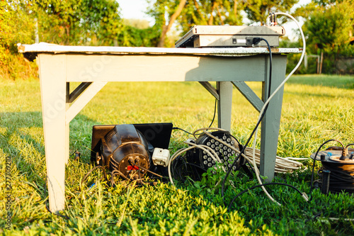 Equipment for party outside. Par light with a computer standing on the grass, dj mixer on the table. photo