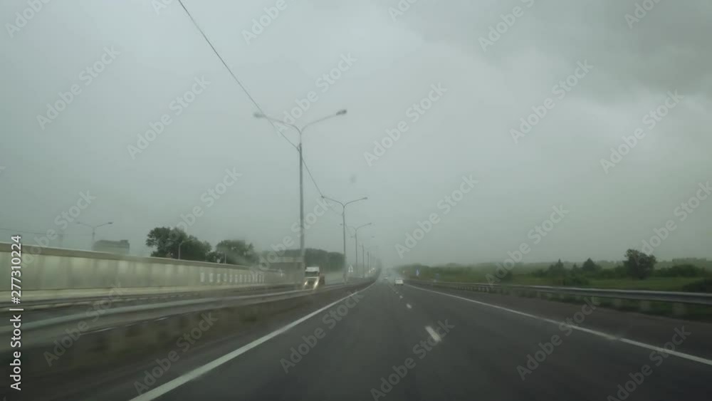 View on highway through wet windshield in rain storm. View on highway through wet windshield in rain storm.