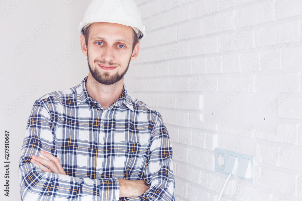 worker with yellow helmet and jeans shirt near a industrial wall worker with yellow helmet and jeans shirt near a industrial wall