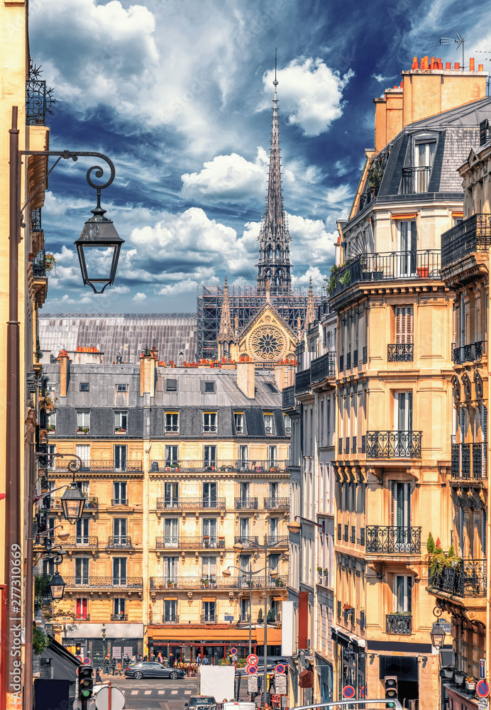 Latin Quarter street view of Paris, France. Blue sky, buildings and traffic. Shot in april daylight with Notre Dame in the background. - obrazy, fototapety, plakaty 