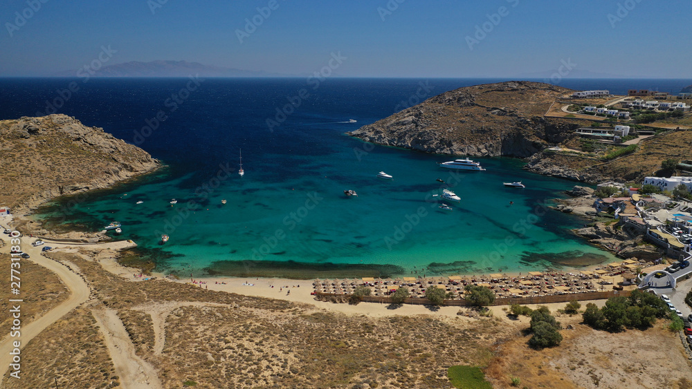 Aerial drone photo of small peninsula with picturesque chapel and beach of Agia Anna as well as small beach of Divounia, island of Mykonos, Cyclades, Greece