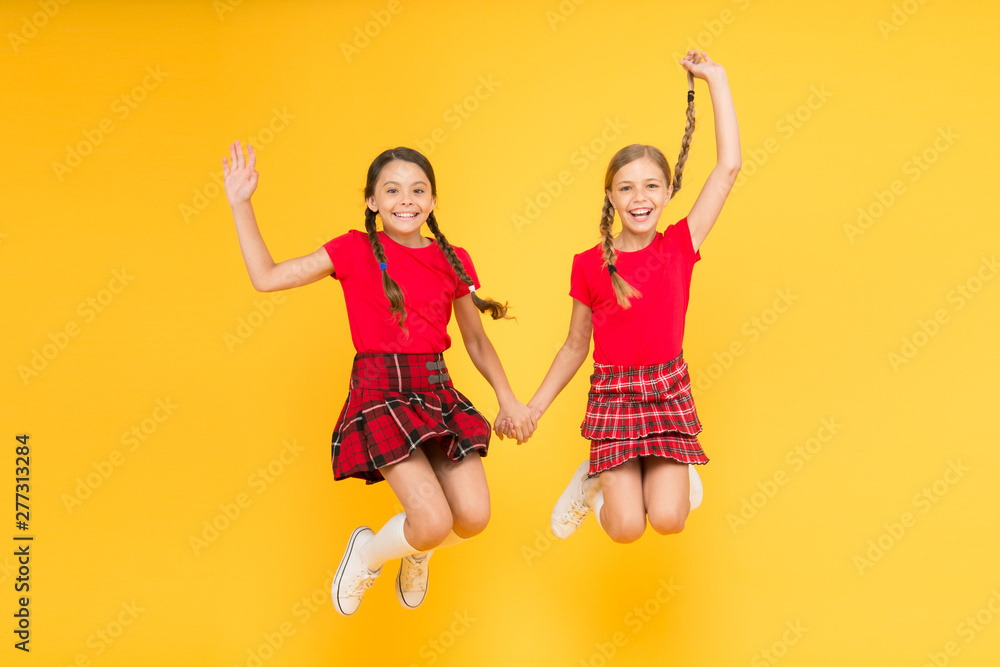 Join celebration. Kids girl wear checkered dresses. National holiday. School uniform. Scottish style. Cheerful friends schoolgirls jumping yellow background. Celebrate holiday. Scottish holiday - obrazy, fototapety, plakaty 